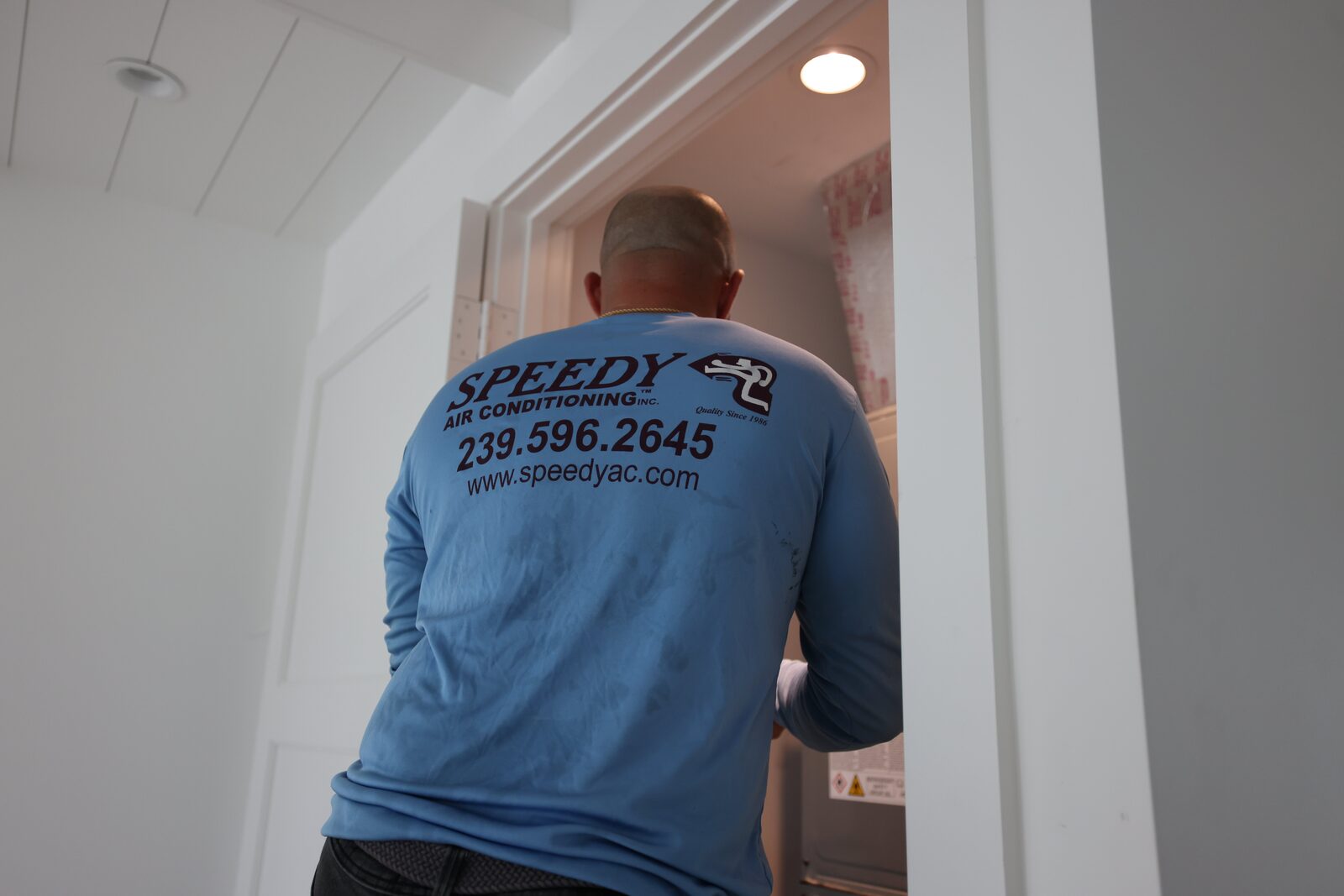 Speedy tech heading into the air handler closet on a Naples build